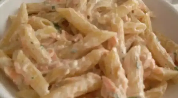 Penne cremose con salmone e panna, un piatto delizioso pronto per essere gustato.