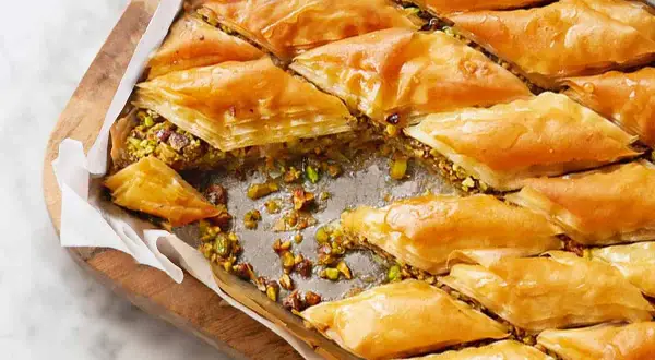 Delizioso baklava ricetta con strati croccanti di pasta fillo, ripieno di pistacchi e sciroppo dorato.