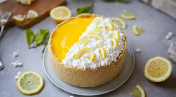 Delizioso cheesecake al limone con crema e fette di limone, pronto per essere gustato.