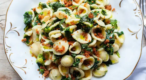 Orecchiette cime di rapa fumanti, un piatto tradizionale pugliese con pasta fresca, verdure amare e mollica tostata.