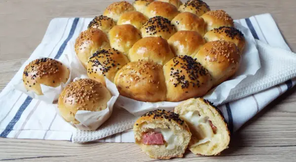 Un soffice danubio salato, con palline ripiene di formaggio e wurstel, guarnite con semi di sesamo bianchi e neri.