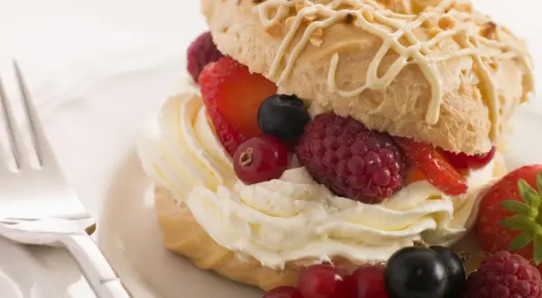 Delizioso pasticcino con chantilly e frutti di bosco freschi, pronto per essere gustato.