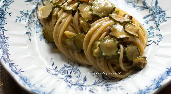 Spaghetti alla Nerano, un piatto cremoso con zucchine fresche su un piatto decorato.