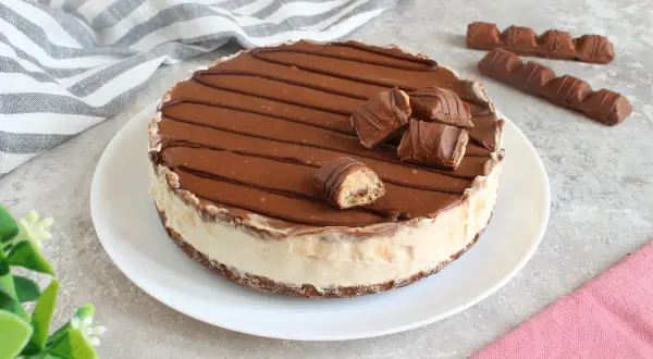 Cheesecake kinder con copertura al cioccolato e pezzi di barretta. Un dolce goloso per veri amanti del cioccolato.