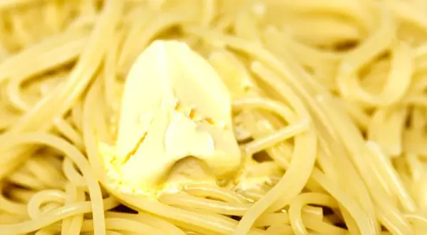 Un piatto di pasta in bianco fumante, con una generosa noce di burro che si scioglie lentamente tra gli spaghetti.
