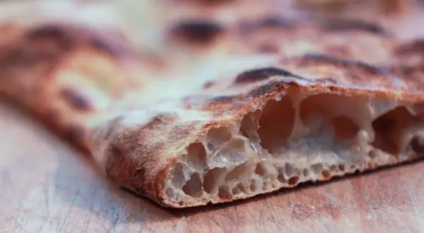 La pizza bonci, con la sua alveolatura perfetta e la crosta dorata, è un'opera d'arte culinaria.