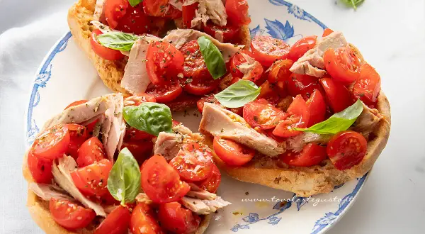 Friselle con pomodorini freschi, tonno e basilico, un piatto estivo leggero e gustoso.