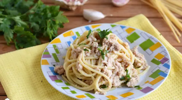 Spaghetti conditi con tonno in scatola, prezzemolo e aglio. Un piatto semplice e gustoso.