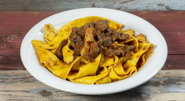 Pappardelle al cinghiale, un piatto ricco e saporito, con pasta fresca e ragù di cinghiale cotto lentamente.