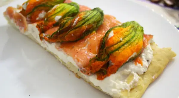 Focaccia con fiori di zucca, salmone affumicato e ricotta. Un piatto colorato e gustoso.