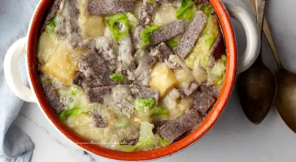 Pizzoccheri ricetta: un piatto fumante in una casseruola con pasta di grano saraceno, patate, verza e formaggio fuso.