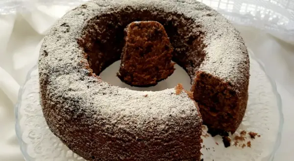 Un delizioso ciambellone al cioccolato, cosparso di zucchero a velo, pronto per essere gustato.