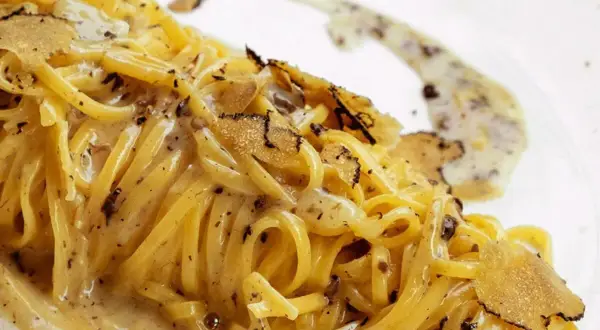 Tagliolini al tartufo, un piatto cremoso e profumato, con scaglie di tartufo nero che ne esaltano il sapore.