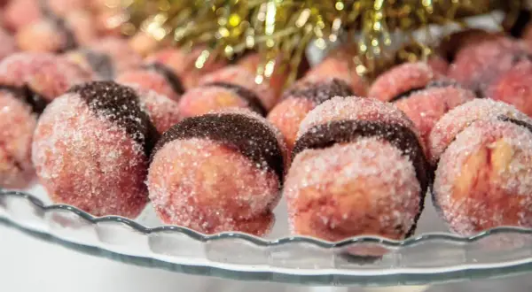 Dolci con alchermes, rotondi e zuccherini, con una fascia scura al centro, pronti per le feste.
