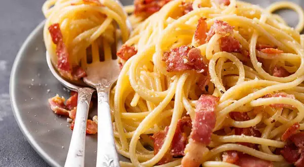 Spaghetti alla carbonara ricetta: un piatto cremoso con guanciale croccante e pecorino romano.