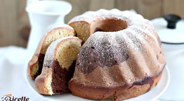 Un delizioso ciambellone bicolore, con cacao e vaniglia, spolverato di zucchero a velo, pronto per essere gustato.