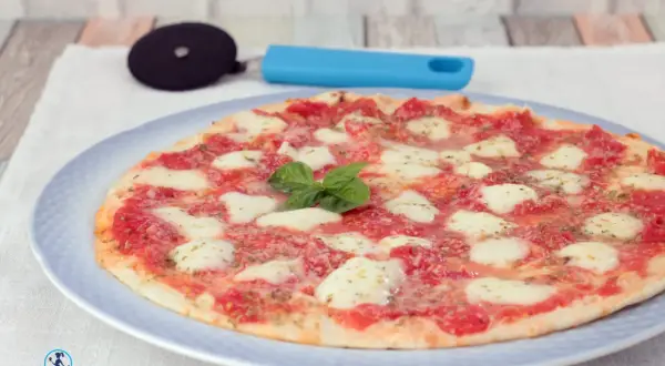 Piadipizza margherita appena sfornata, con pomodoro, mozzarella filante e basilico fresco. Perfetta per una cena veloce in padella.