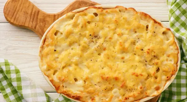 Delizioso pasta al forno bianca napoletana, dorata e filante, pronta per essere gustata.