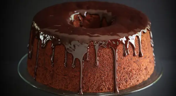 Delizioso chiffon cake al cioccolato con glassa fondente che cola.