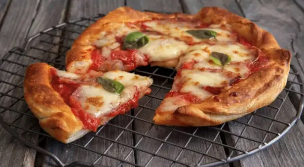Pizza in friggitrice ad aria, croccante e filante, con pomodoro e mozzarella, guarnita con basilico fresco.