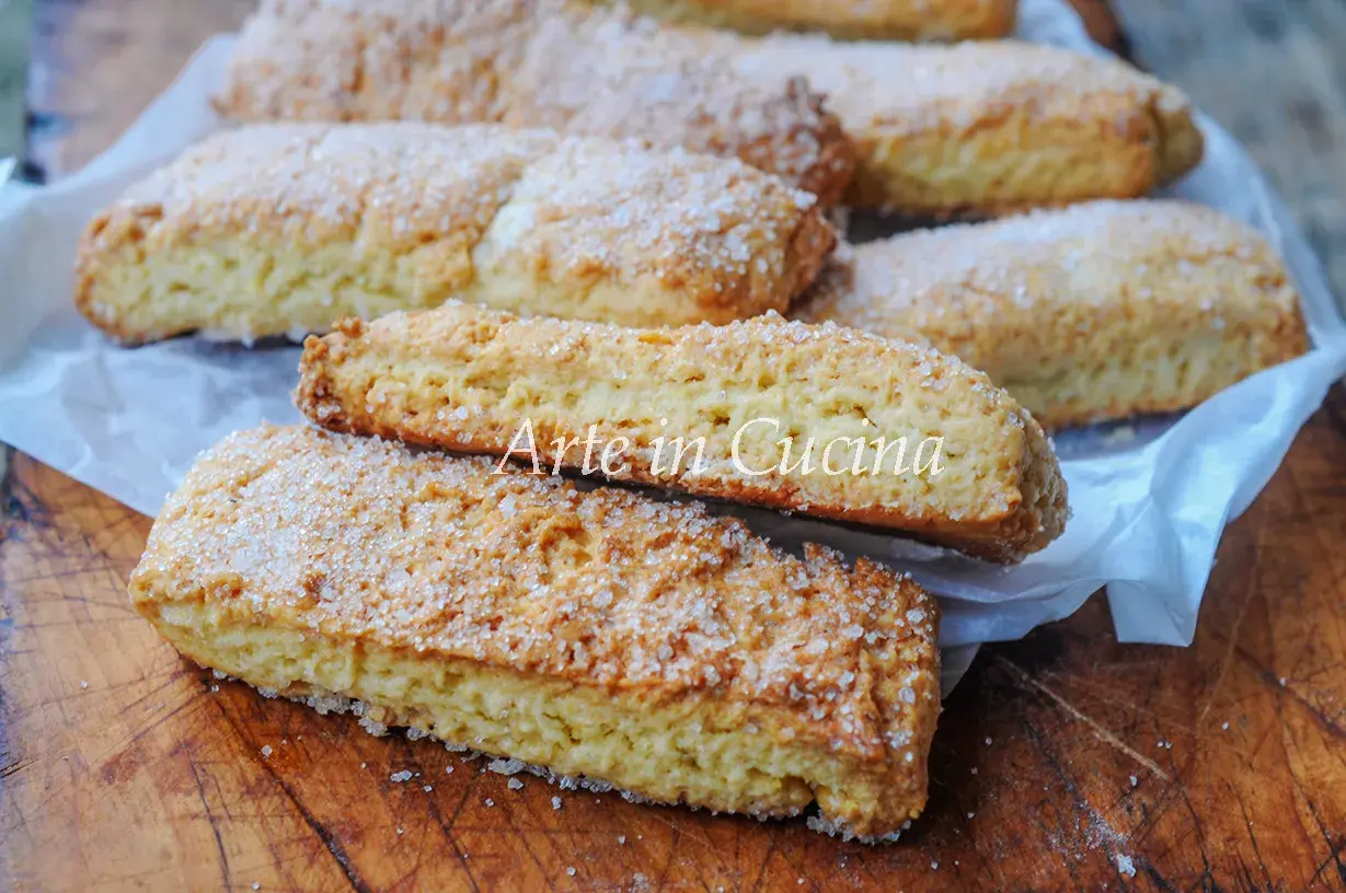 Biscotti pasta frolla dorati e croccanti, cosparsi di zucchero, pronti per essere gustati.