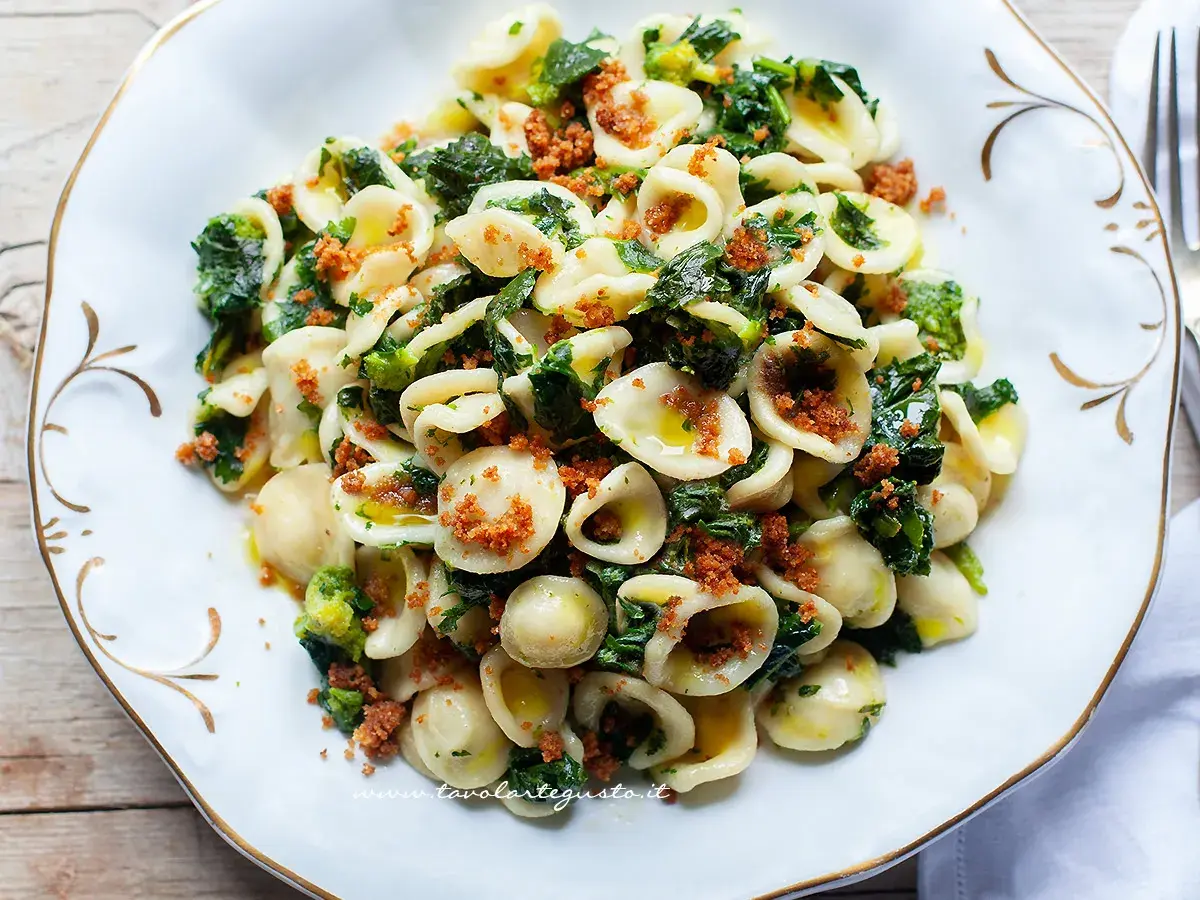 Orecchiette cime di rapa fumanti, un piatto tradizionale pugliese con pasta fresca, verdure amare e mollica tostata.