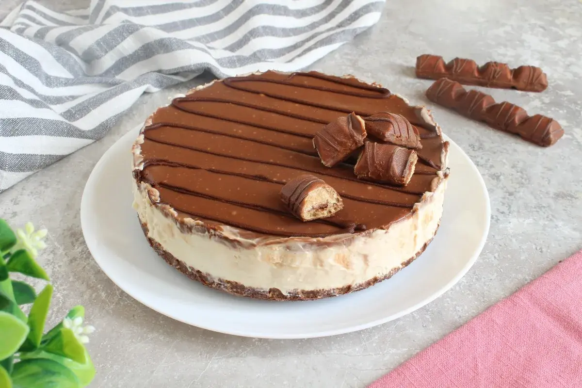 Cheesecake kinder con copertura al cioccolato e pezzi di barretta. Un dolce goloso per veri amanti del cioccolato.