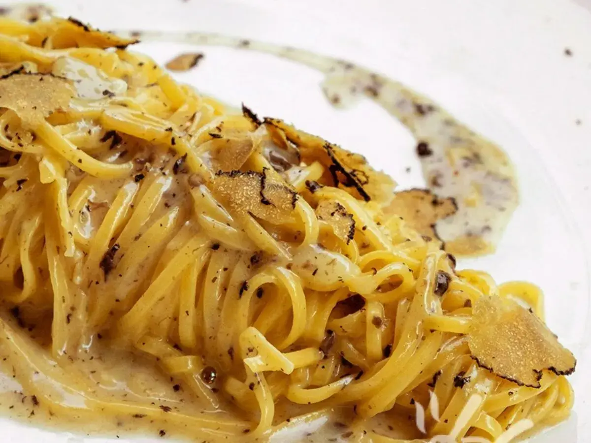 Tagliolini al tartufo, un piatto cremoso e profumato, con scaglie di tartufo nero che ne esaltano il sapore.