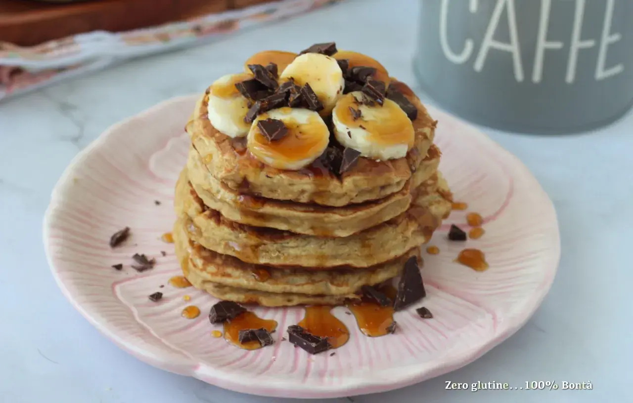 Pancake banana e yogurt, una pila golosa con scaglie di cioccolato e sciroppo d'acero.