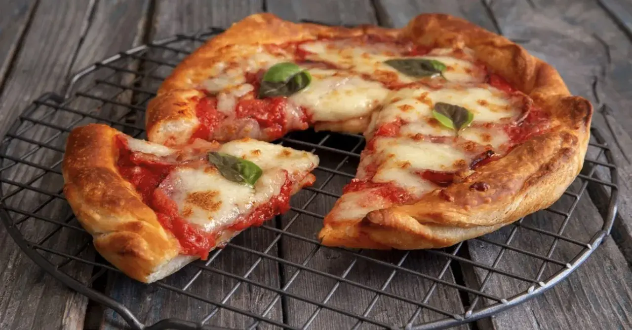 Pizza in friggitrice ad aria, croccante e filante, con pomodoro e mozzarella, guarnita con basilico fresco.