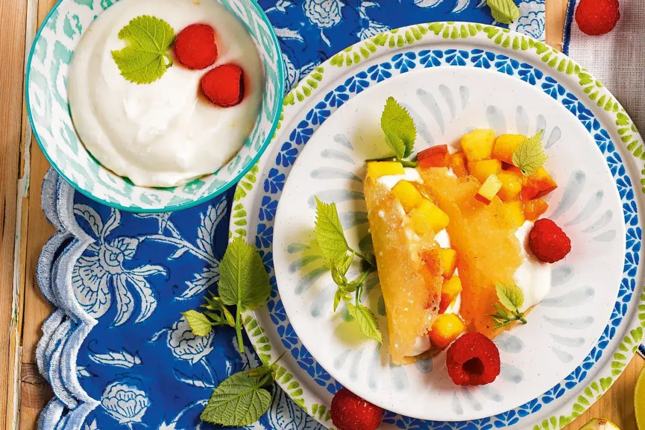Crepes ripiene di frutta fresca e yogurt, un'idea perfetta per dolci estivi. Lamponi e menta completano il piatto.