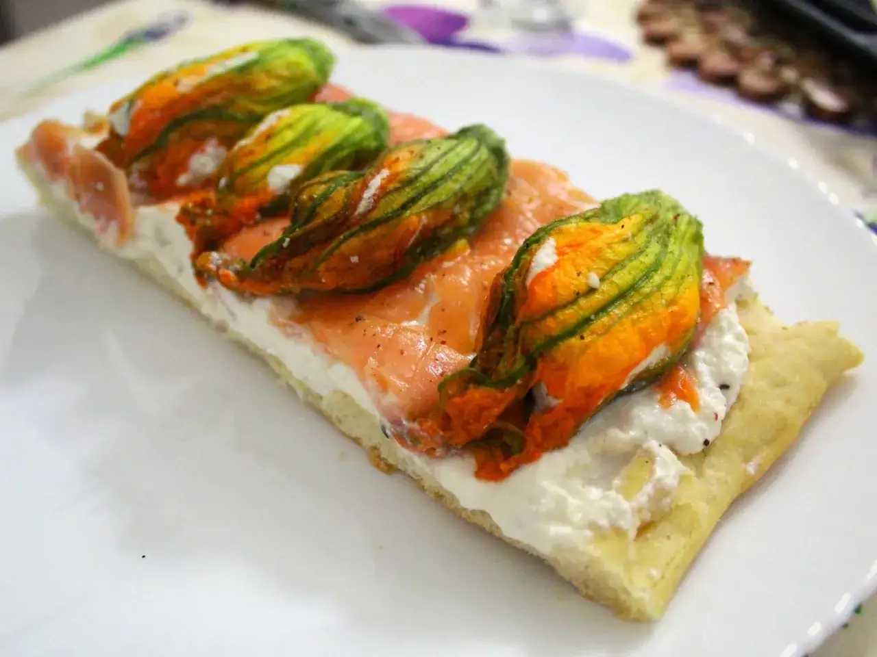 Focaccia con fiori di zucca, salmone affumicato e ricotta cremosa. Un boccone estivo che profuma di sole e mare.