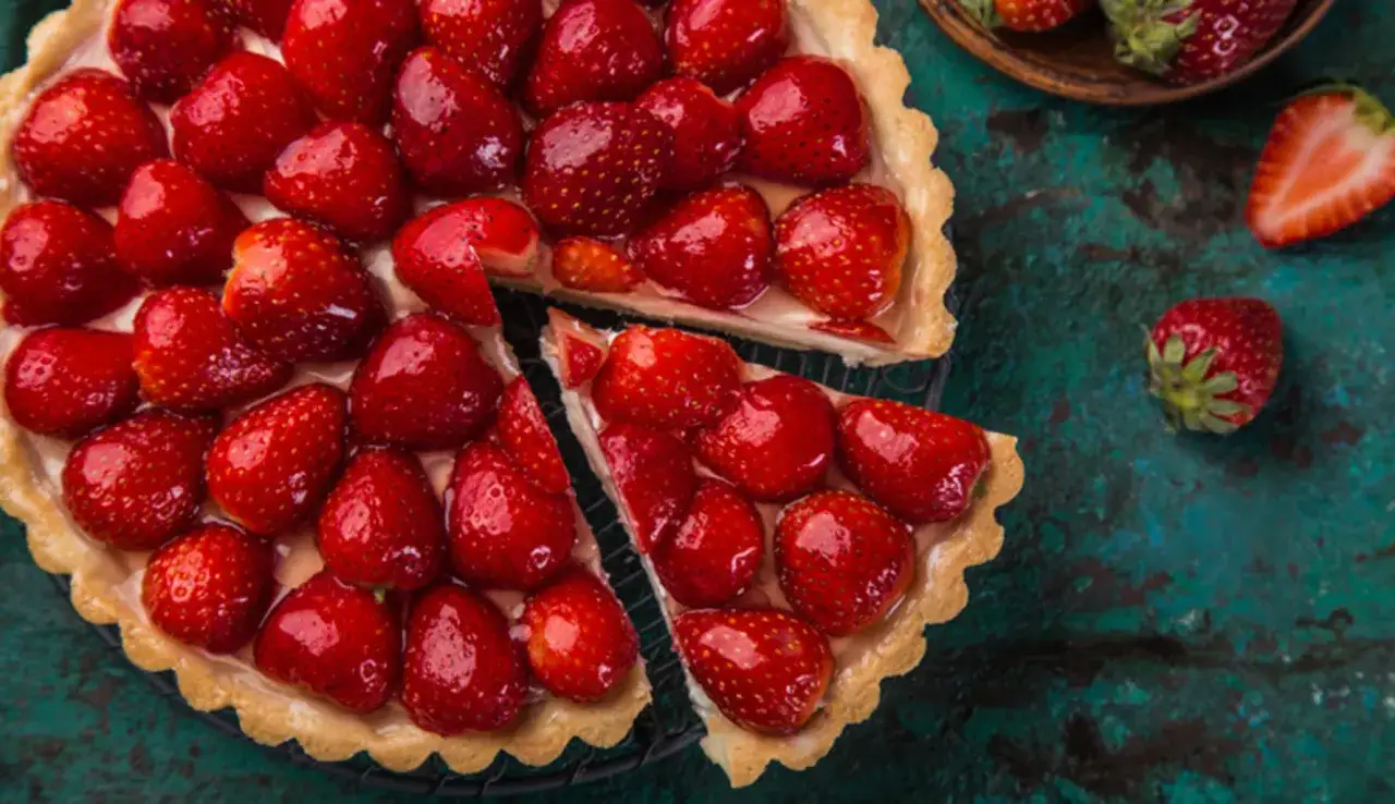 Una deliziosa crostata di frutta, ricca di fragole rosse e succose, su una base dorata e cremosa.