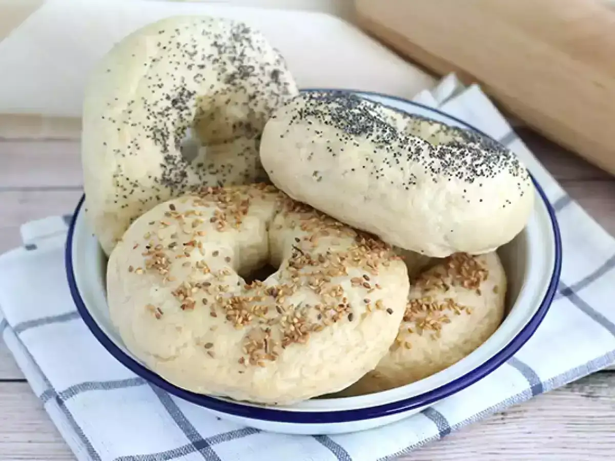 Bagel ricetta: ciotola piena di bagel fatti in casa, alcuni con semi di sesamo, altri con semi di papavero.