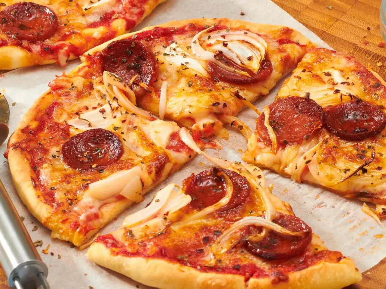 Pizza in friggitrice ad aria con salame piccante e cipolle. Croccante e saporita, perfetta per uno spuntino veloce.