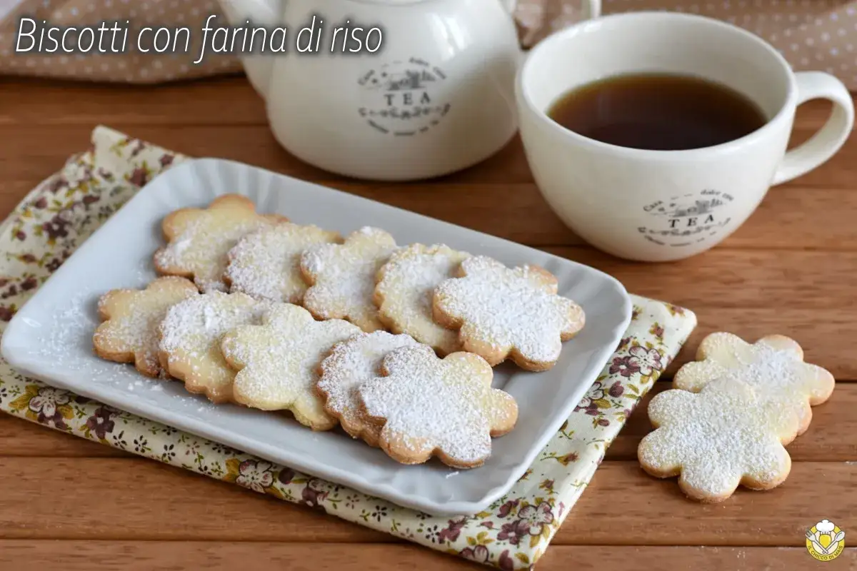 Biscotti con farina di riso a forma di fiore, spolverati di zucchero a velo, serviti con una tazza di tè.