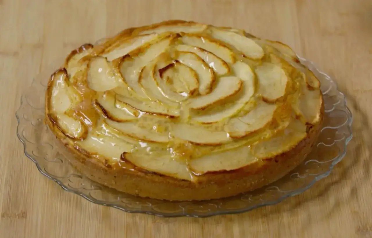 Una deliziosa torta di mele, con fette disposte a spirale e glassate, pronta per essere gustata.
