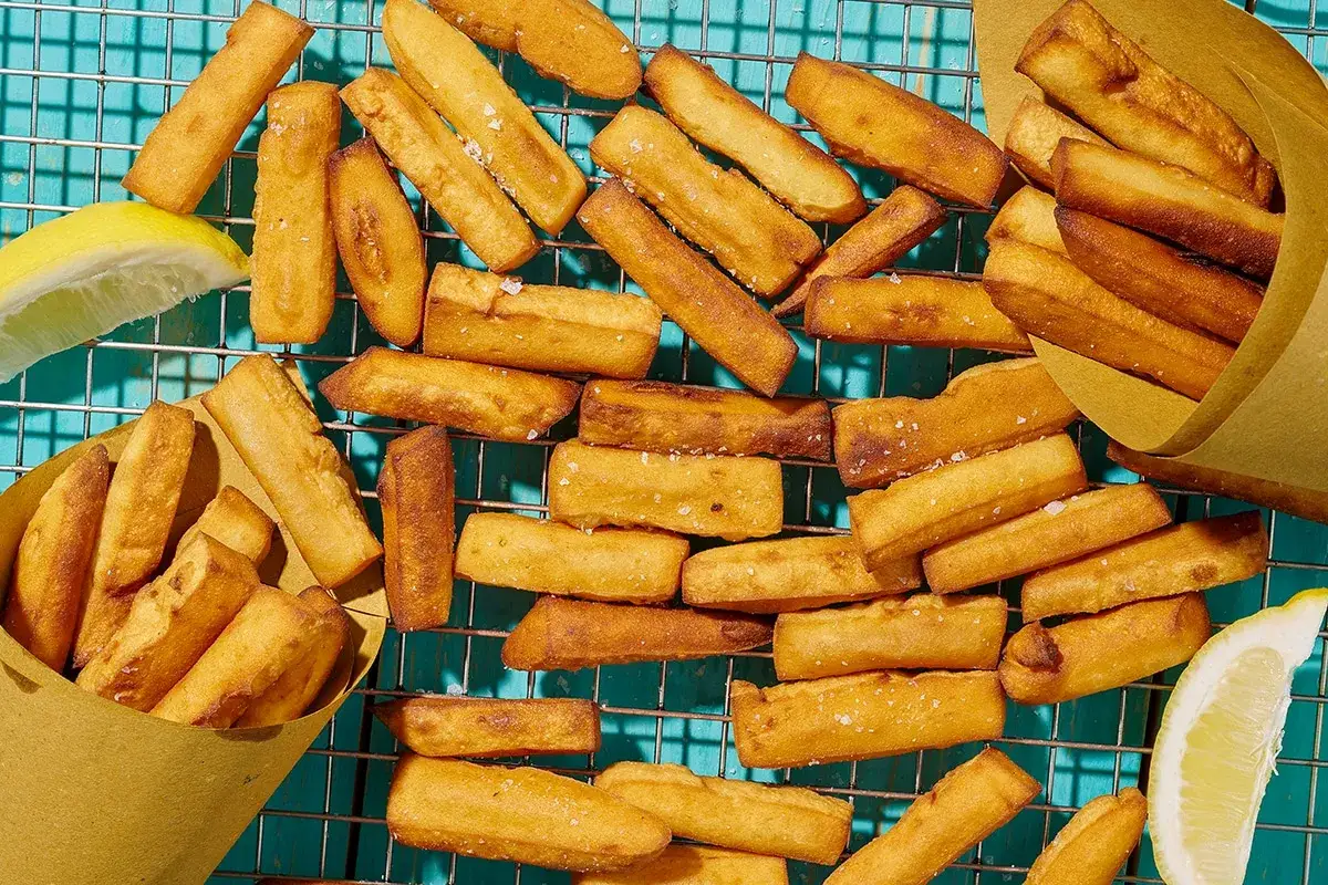 Panissa ligure dorata e croccante, servita su una griglia con spicchi di limone. Un sapore autentico della Liguria.