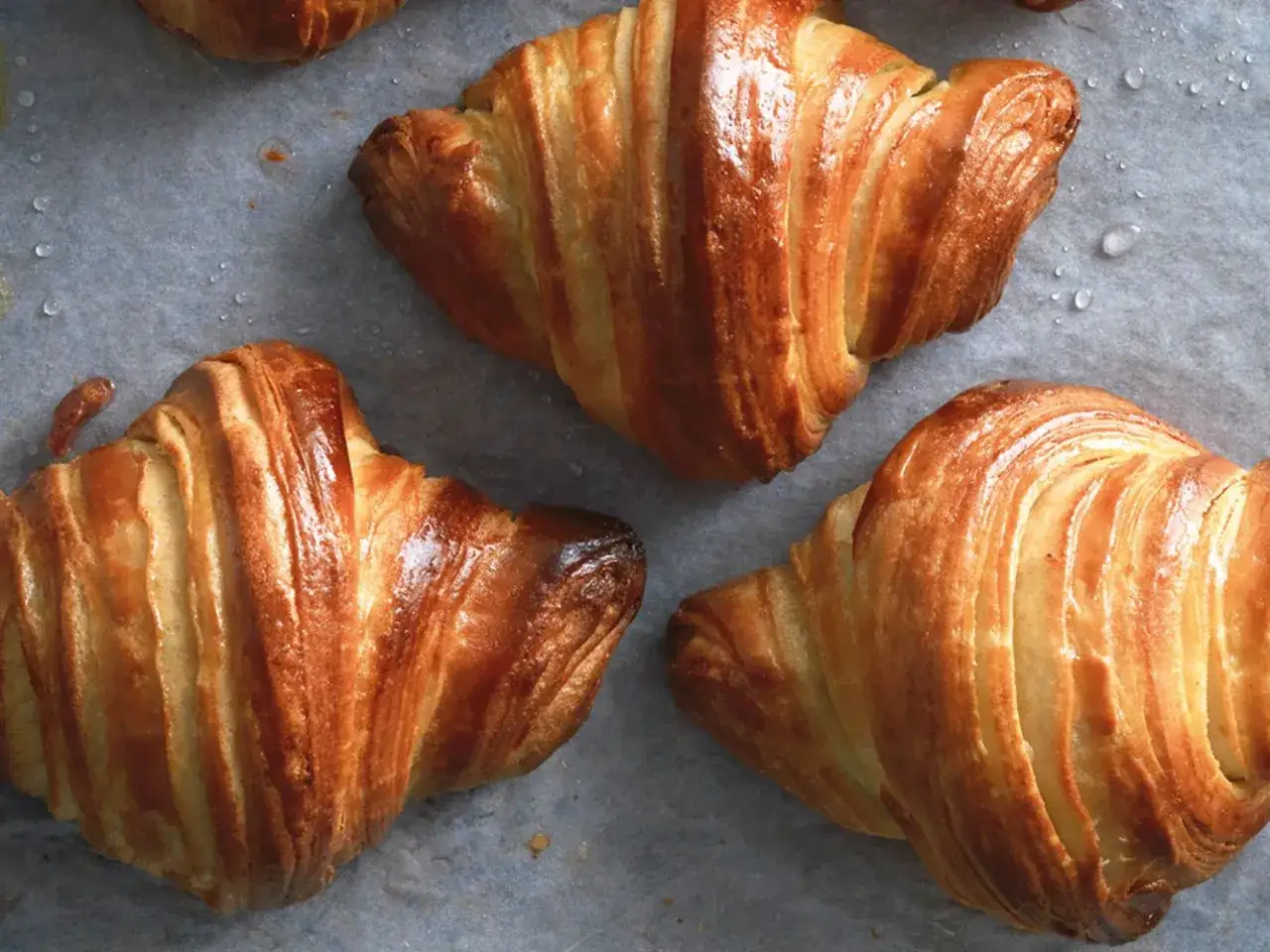 Cornetti fatti in casa dorati e sfogliati, pronti per essere gustati. La ricetta perfetta per una colazione golosa.