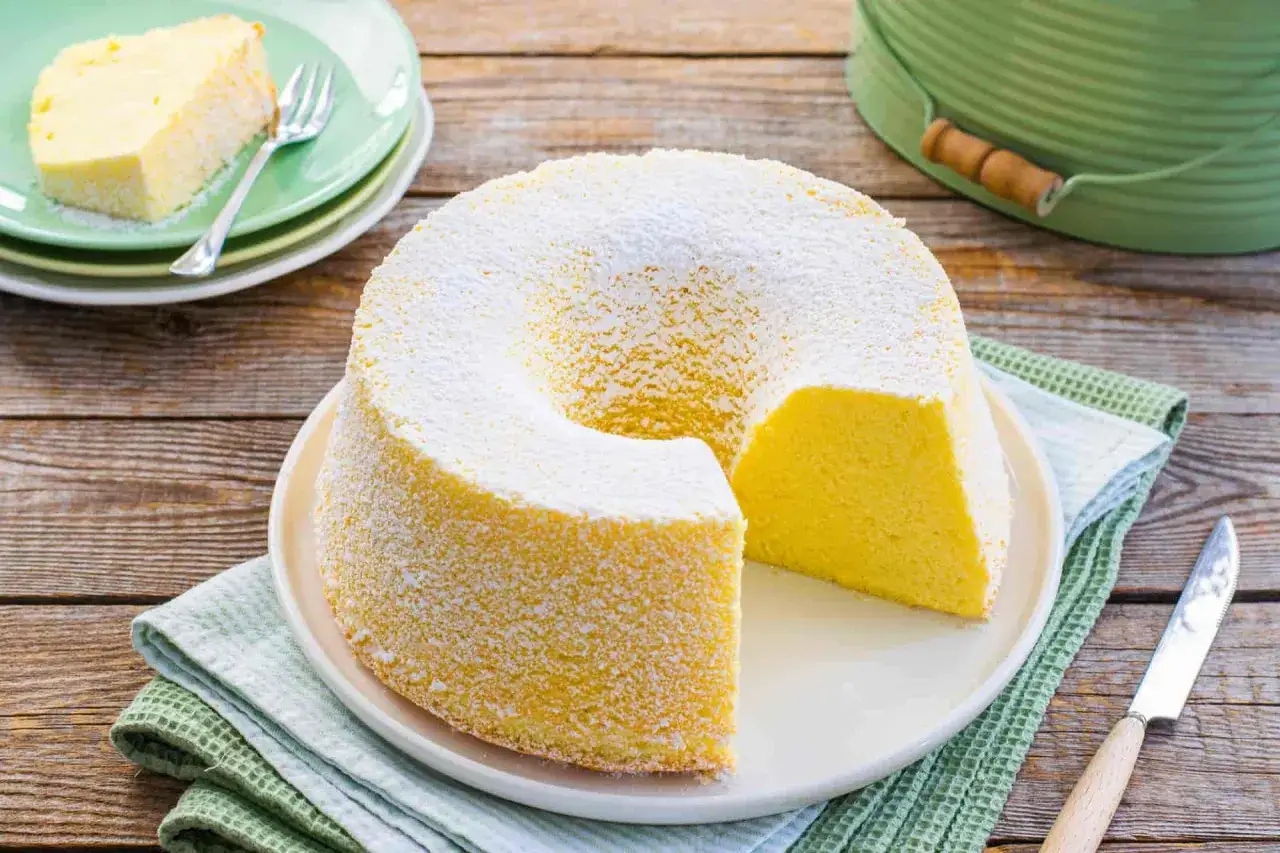Un soffice chiffon cake spolverato di zucchero a velo, pronto per essere gustato.