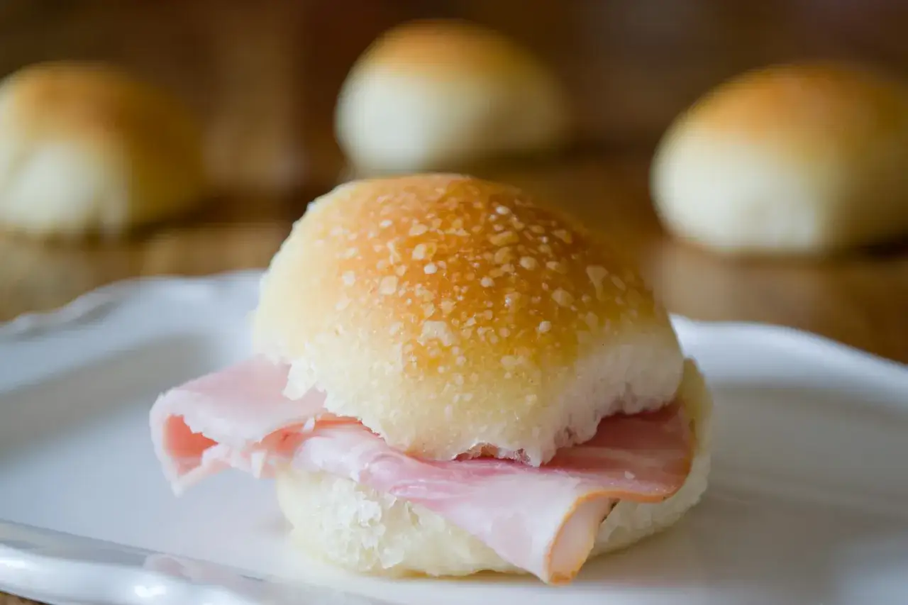 Panini all'olio con prosciutto, morbidi e dorati, pronti per essere gustati.