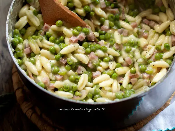 Pasta con prosciutto cotto e piselli, un piatto cremoso e saporito, pronto per essere gustato.