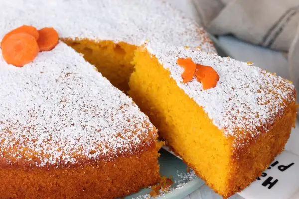 Torta Camilla, ricetta originale: soffice torta all'arancia e carota, spolverata di zucchero a velo e decorata con fettine di carota.