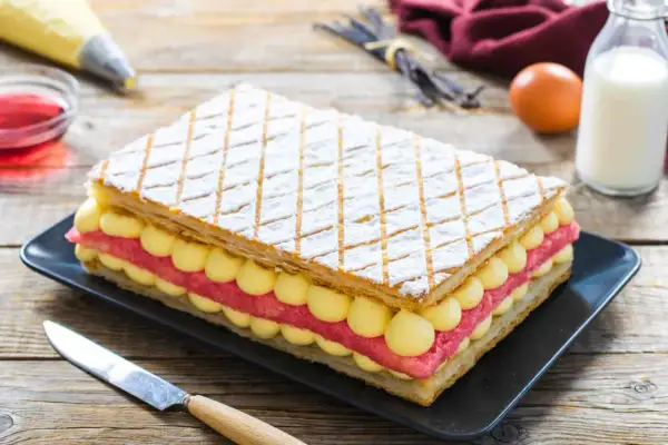 Una deliziosa torta diplomatica, con strati di pasta sfoglia, crema pasticcera e fragole, pronta per essere gustata.