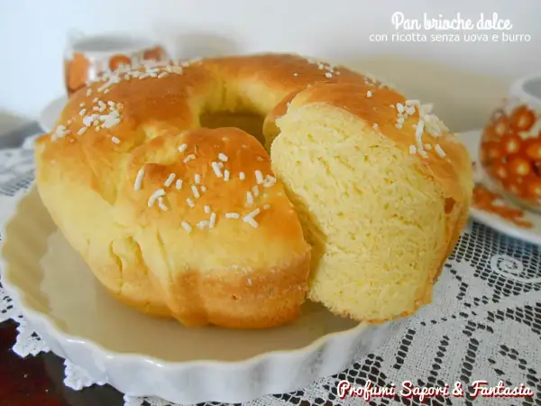 Pan brioche dolce senza uova, soffice e dorato, cosparso di zuccherini. Perfetto per la colazione.