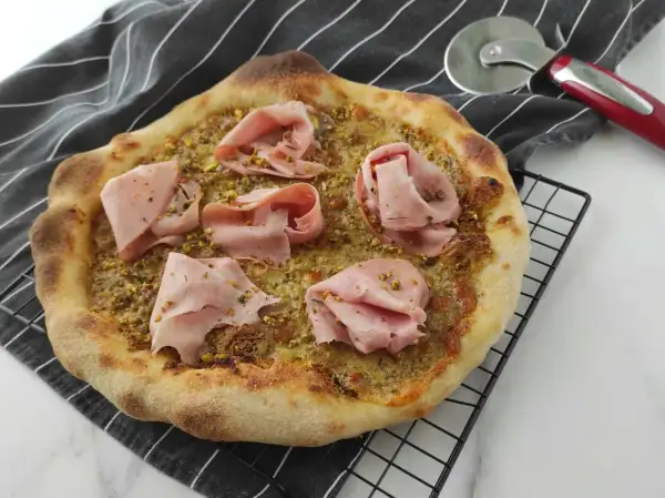 Pizza con mortadella e pistacchio, un connubio di sapori unico.