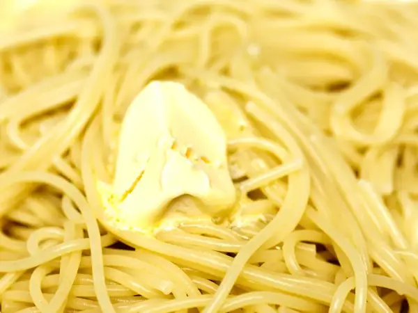 Un piatto di pasta in bianco fumante, con una generosa noce di burro che si scioglie lentamente tra gli spaghetti.