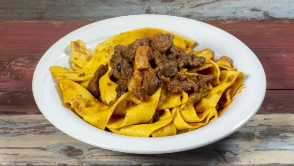 Pappardelle al cinghiale, un piatto ricco e saporito, con pasta fresca e ragù di cinghiale cotto lentamente.