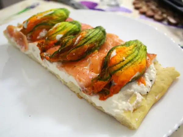 Focaccia con fiori di zucca, salmone affumicato e ricotta. Un piatto colorato e gustoso.