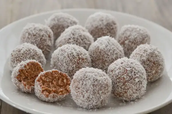 Dolci palline di cocco, una delizia da gustare in ogni momento. Una è stata aperta, rivelando il suo interno morbido e invitante.